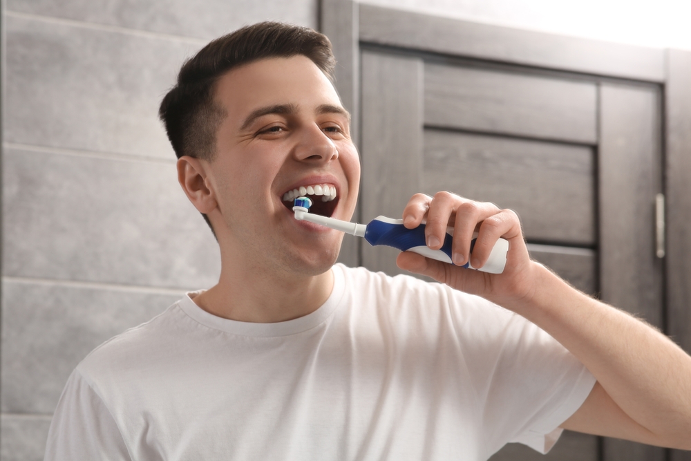 Periuta electrica si simboluri reprezentand beneficiile acesteia